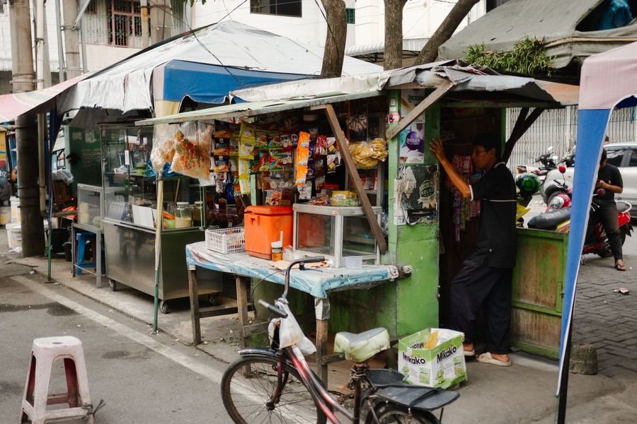 Etalase usaha kecil sepi di siang hari, tidak ada aktivitas terlihat dari luar
