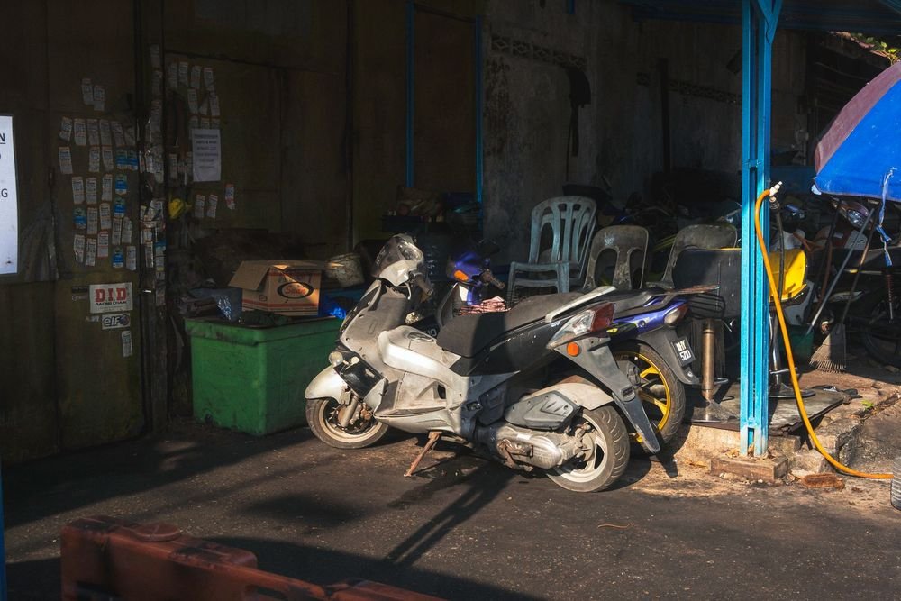 Tampak dalam Bengkel Andi Motor dengan motor pelanggan dan kursi tunggu