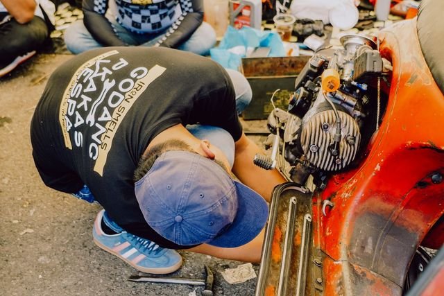 Mekanik Andi Motor memperbaiki mesin motor pelanggan di halaman rumah