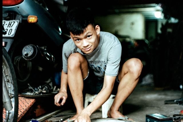 Mekanik muda memasang ban motor di dalam bengkel