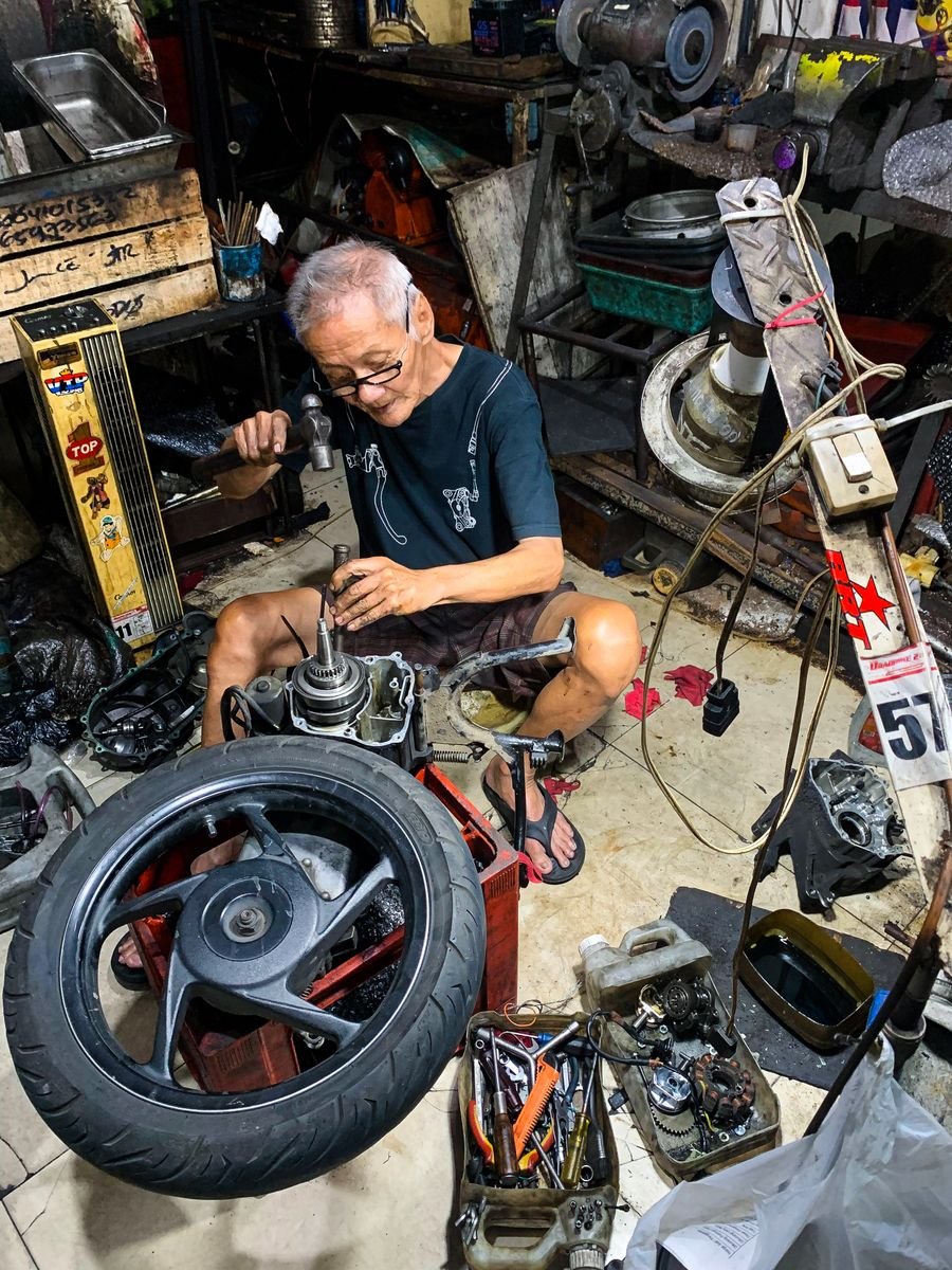 Mekanik membongkar mesin motor tua untuk perbaikan besar