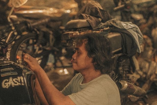 Mekanik mengencangkan baut mesin motor di bengkel