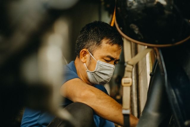 Mekanik memeriksa bagian bawah motor saat servis rutin