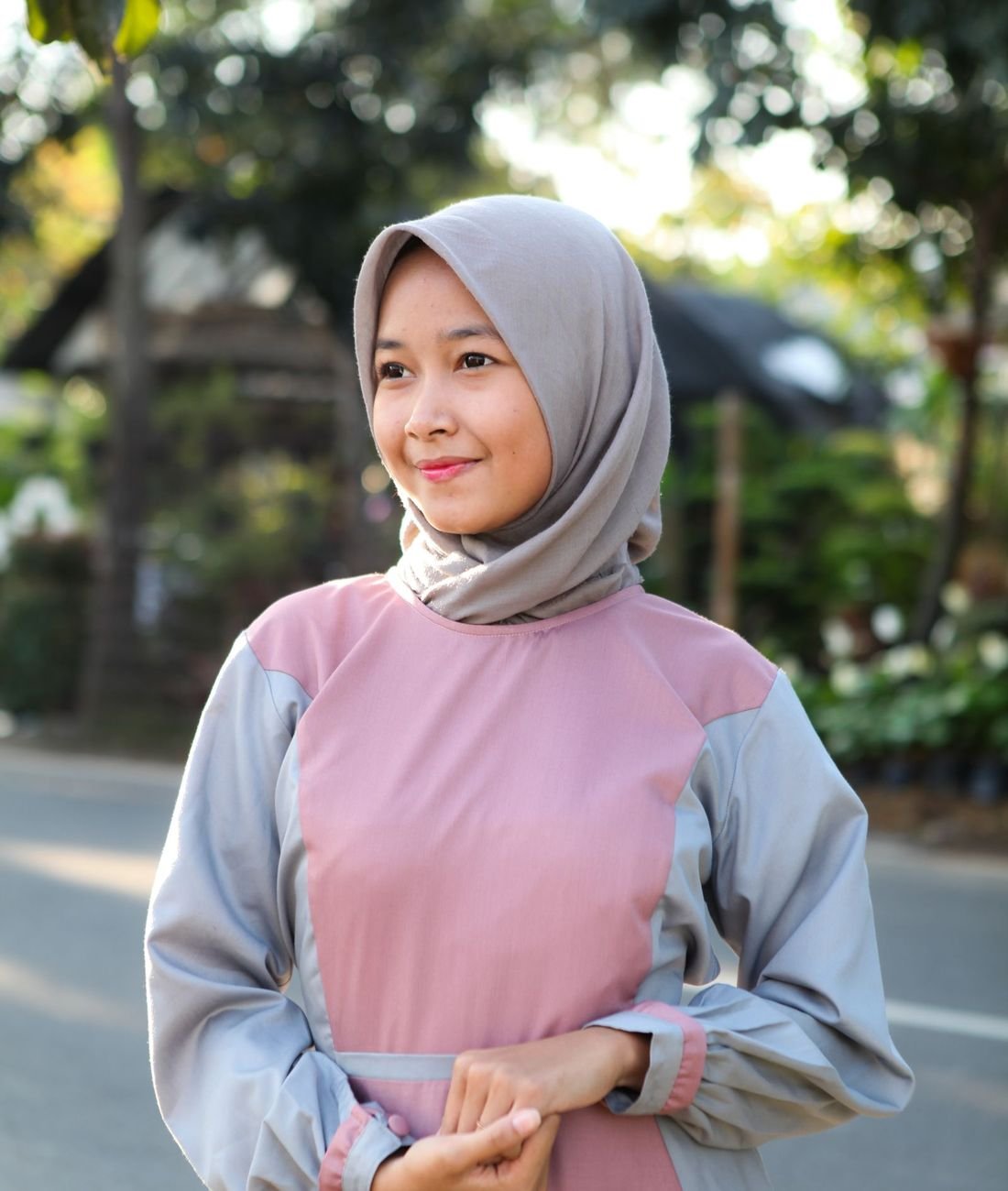 Model mengenakan gamis dua warna dusty pink dan abu dari Zahra Modest
