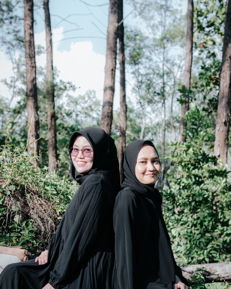 Dua model mengenakan abaya hitam Zahra Modest di hutan pinus